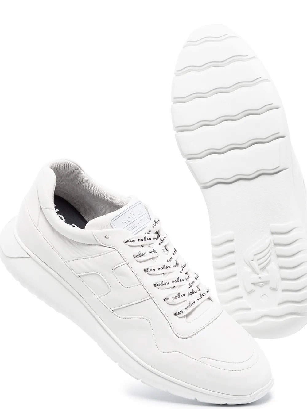 White low-top Hogan lace-up sneakers with treaded outsole visible.
