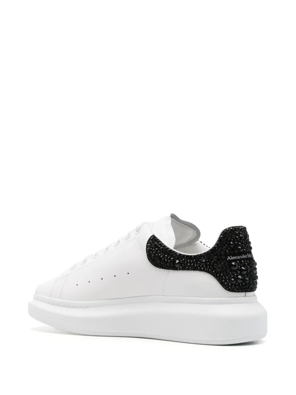White Alexander McQueen low-top sneakers with black heel inserts and padded collar