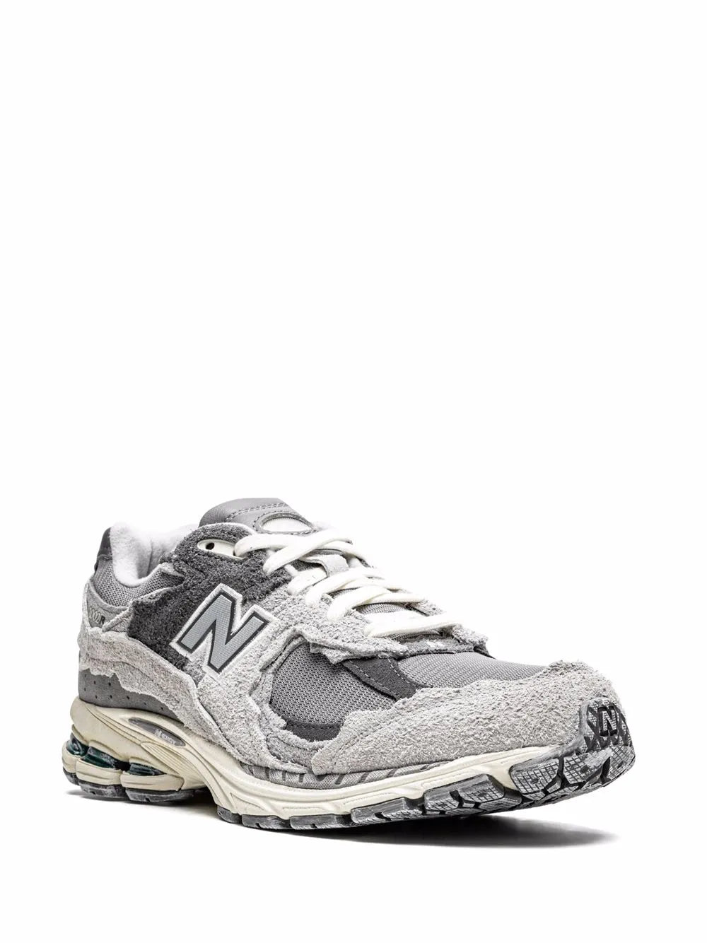 Grey New Balance 2002R sneakers, angled front view with black overlays