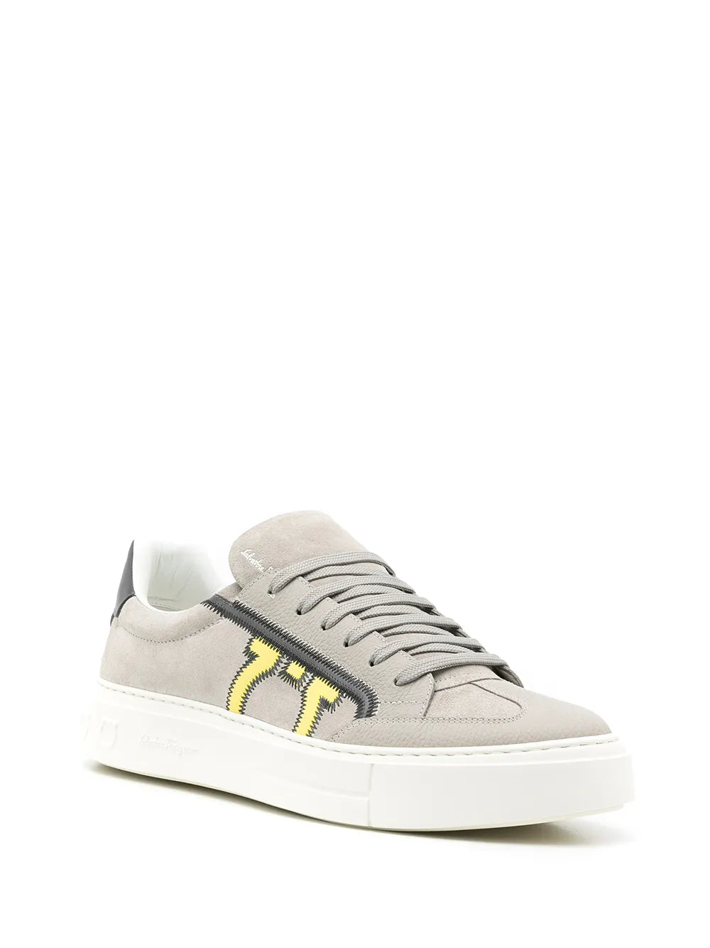Light gray suede low-top sneakers with yellow logo detail and white rubber sole