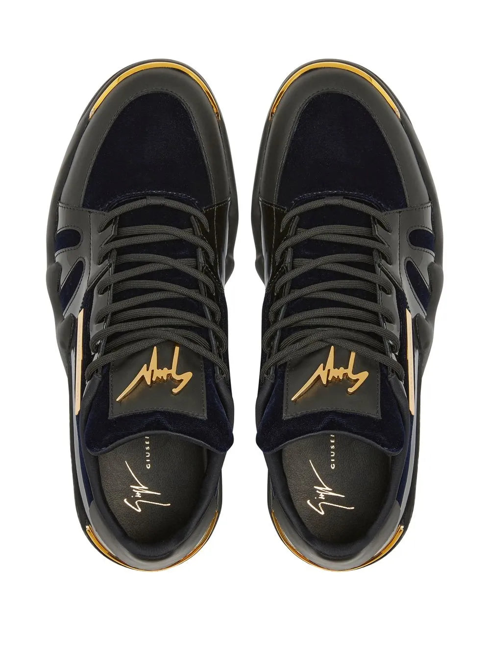 Pair of dark textured low-top sneakers with lace-up front and signature logo on tongue