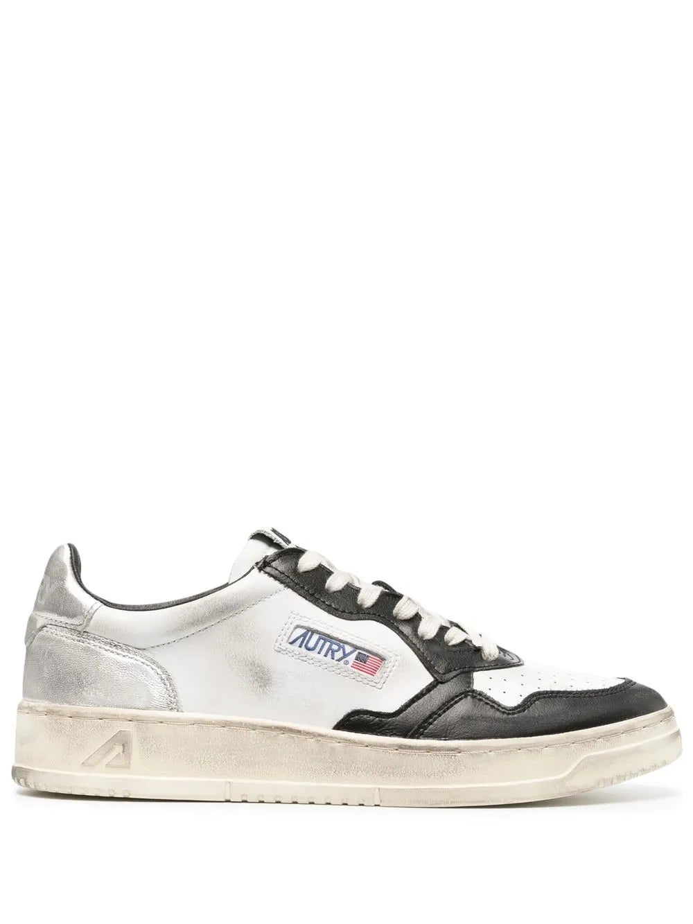 White and black low-top sneakers with lace-up front and side logo patch