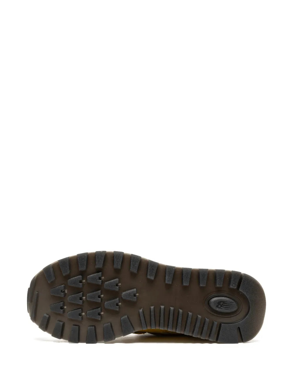 Rubber outsole of yellow New Balance 574 sneakers with deep tread pattern