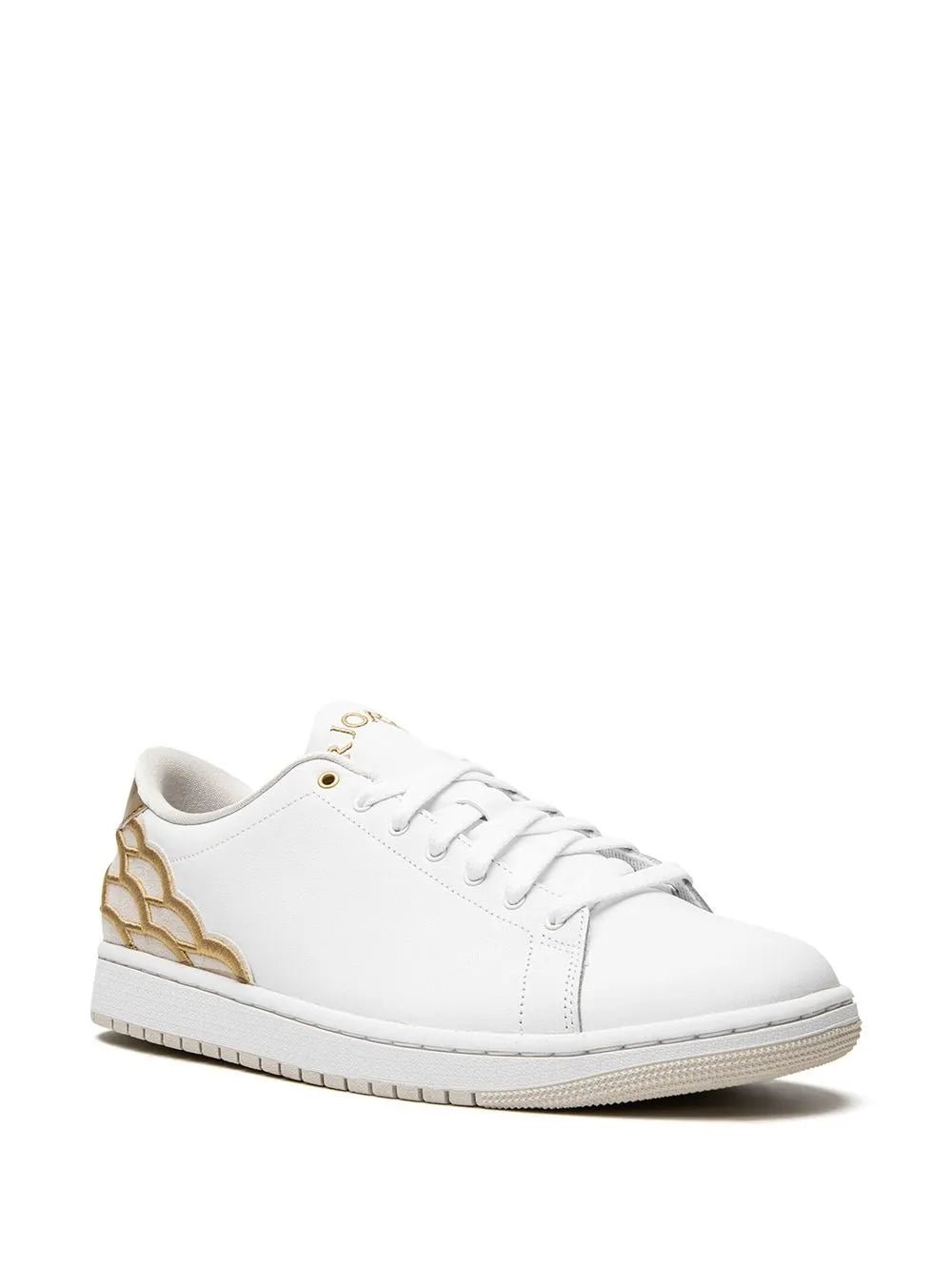 White low-top sneakers with gold side panels, white laces, and stitched toe
