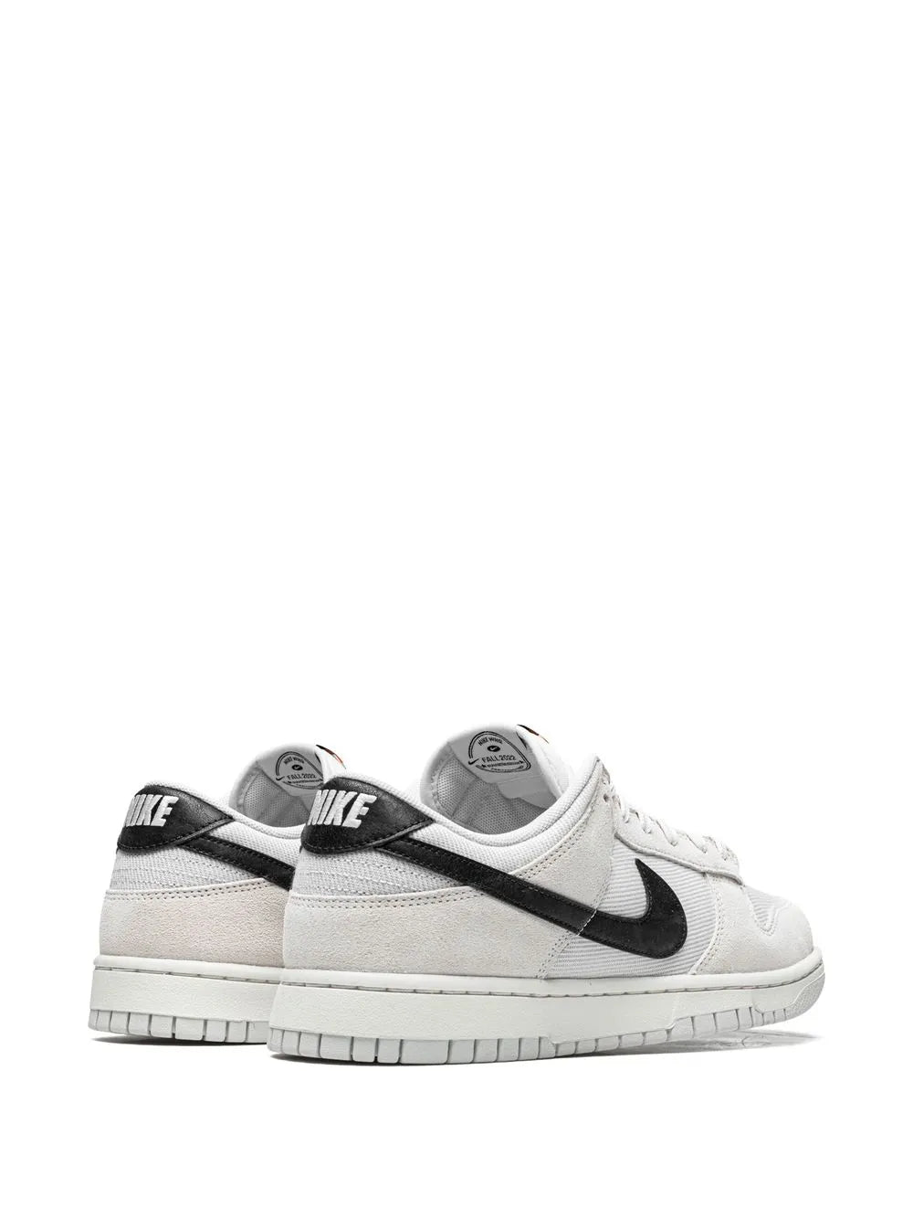 Nike low-top sneakers, black heel panel with 'NIKE' print and white leather.