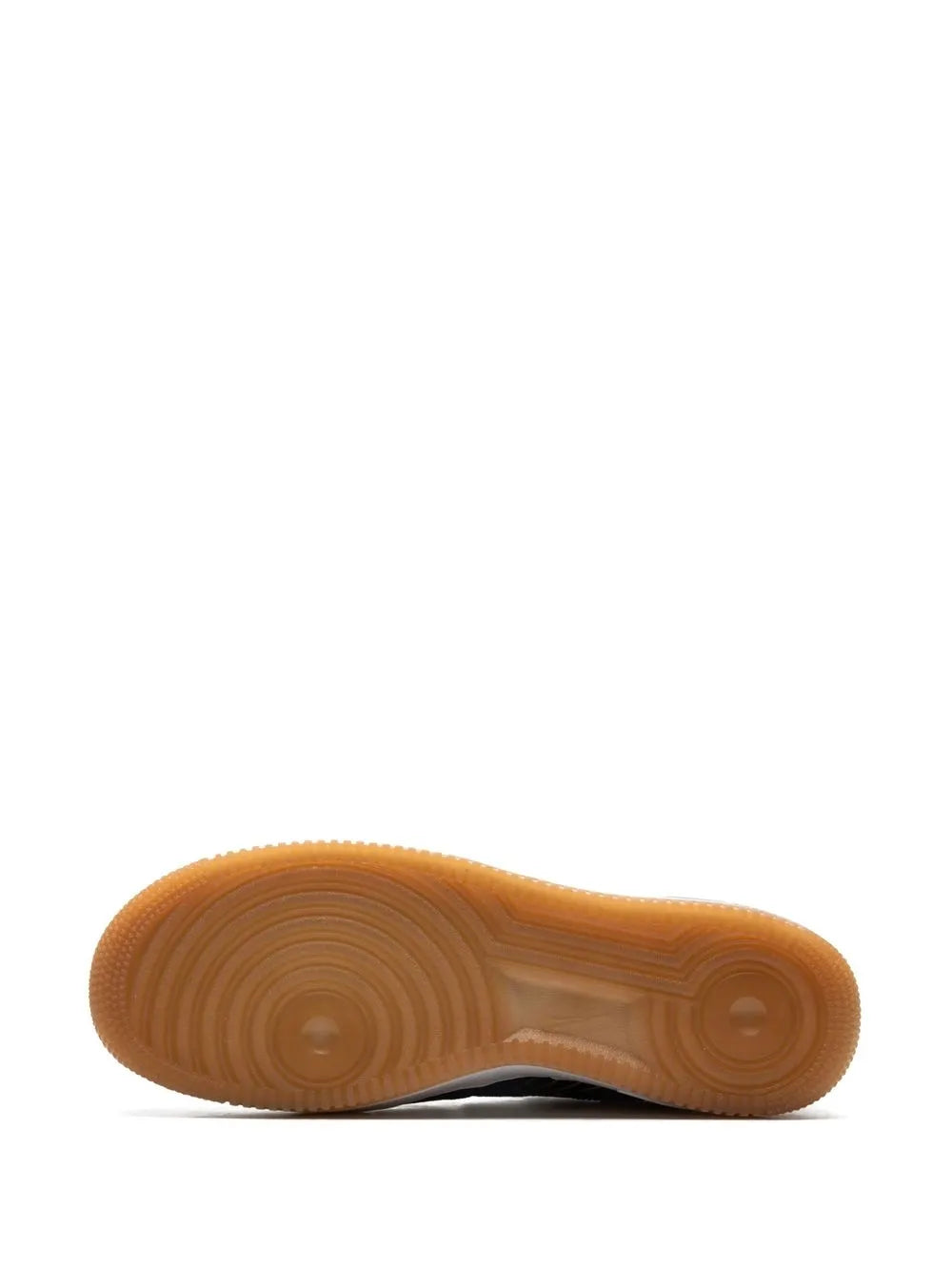 Gum rubber outsole for black Nike low-top sneakers with circular traction pattern