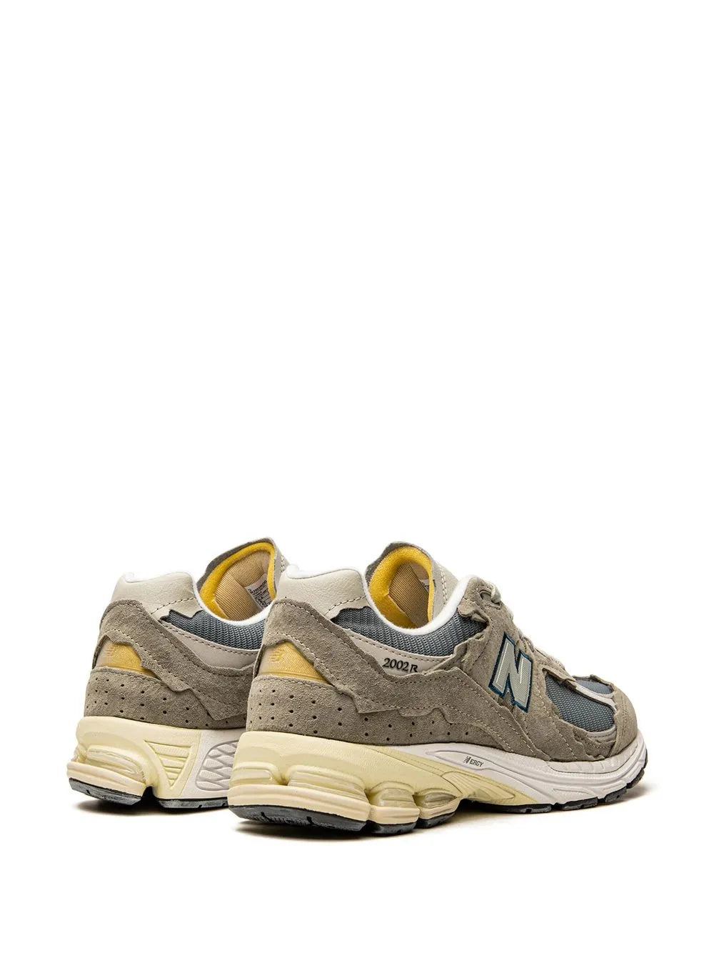 Grey New Balance 2002R sneakers with yellow heel accents, lace-up, cushioned sole