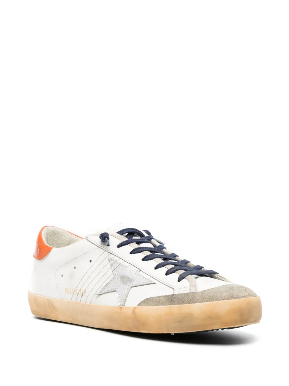Off-white low-top sneakers, navy lace-up, orange collar panel, tan rubber sole.