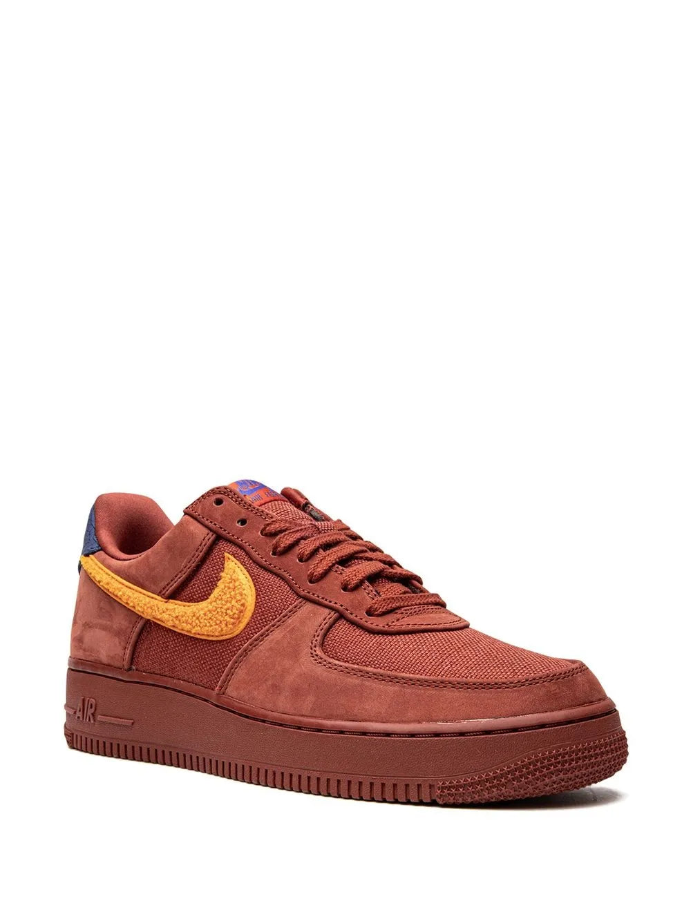 Red suede low-top sneakers with yellow swoosh and blue interior heel lining