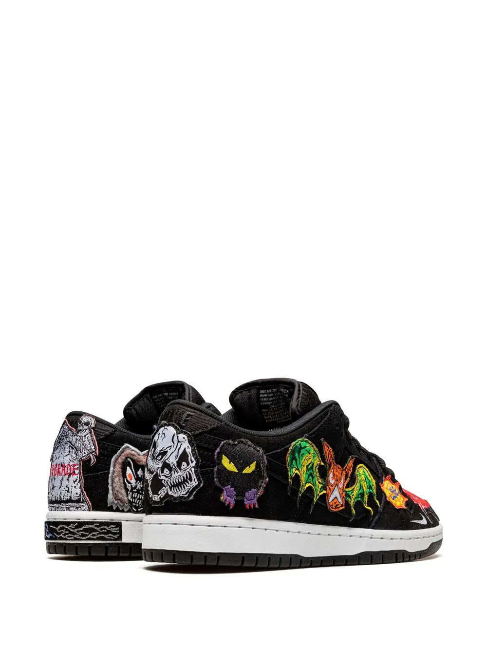 Black low-top skate sneaker with skull and graffiti patch designs on the sides