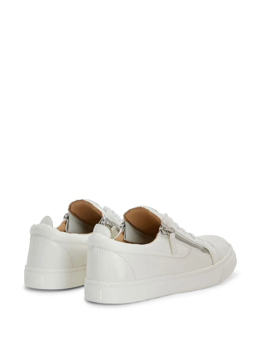 White low-top sneakers with double side zippers, rear and sole visible