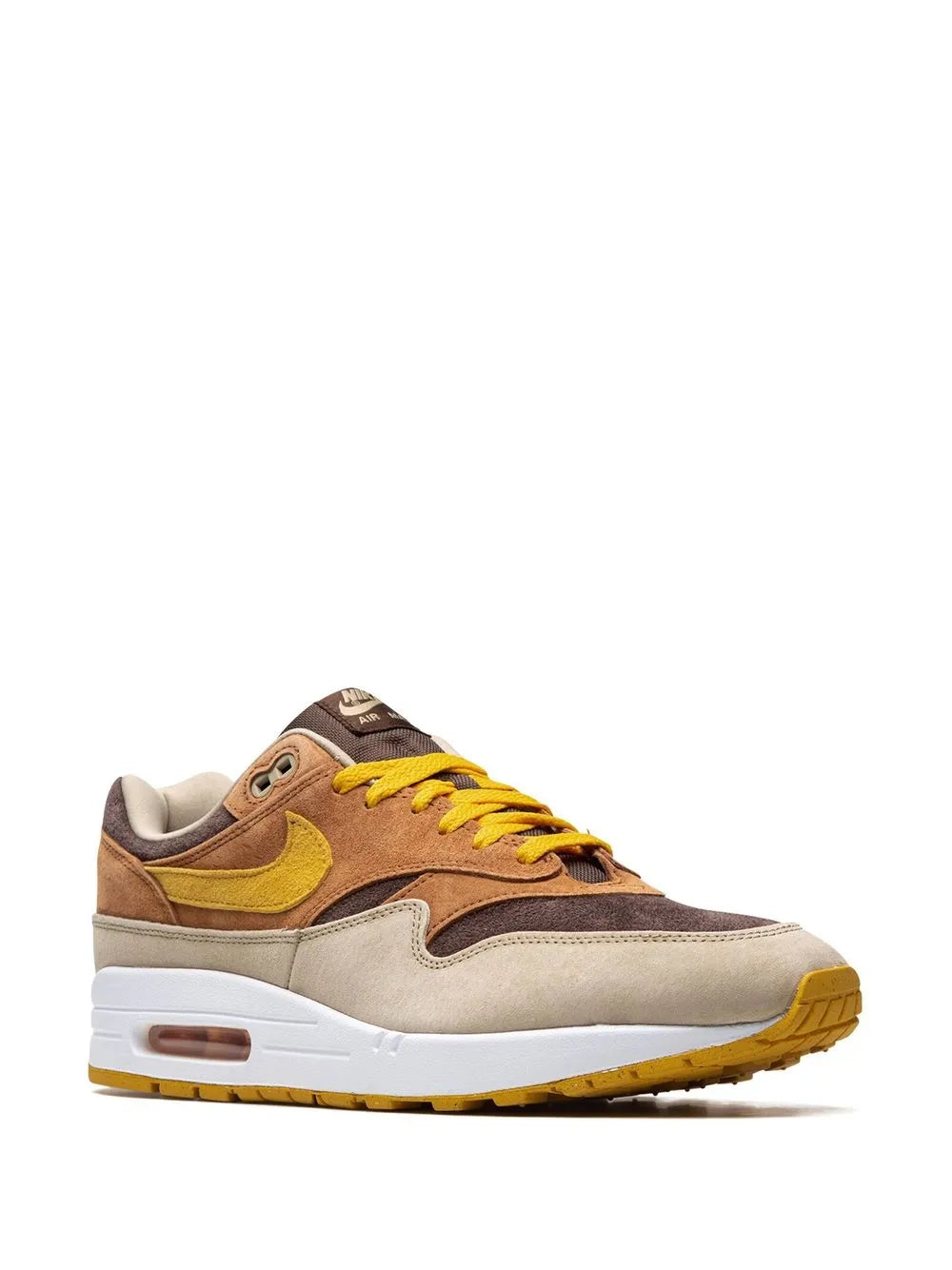 Brown low-top sneaker with yellow swoosh, yellow laces, and beige panels