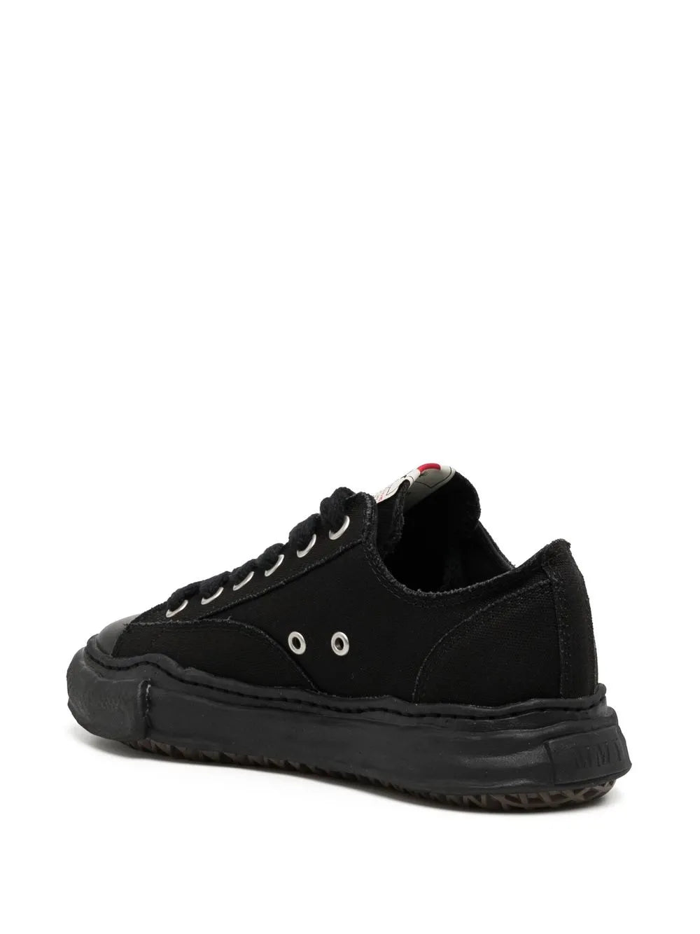 Black low-top canvas sneakers, rear/side view with lace-up and thick sole