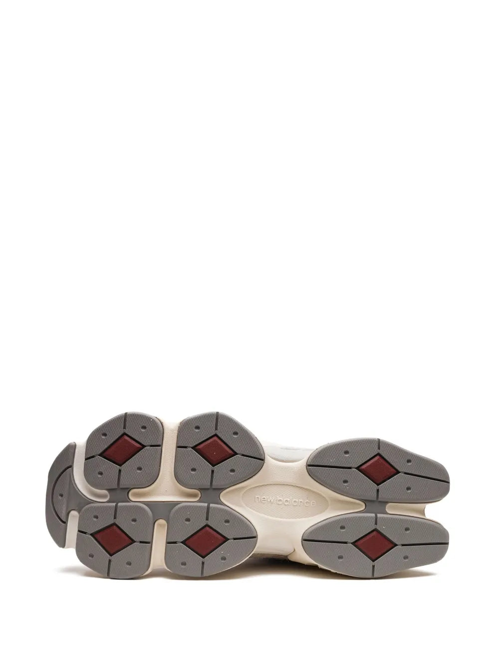 Shoe outsole view with rubber traction pods in dark gray and red accents