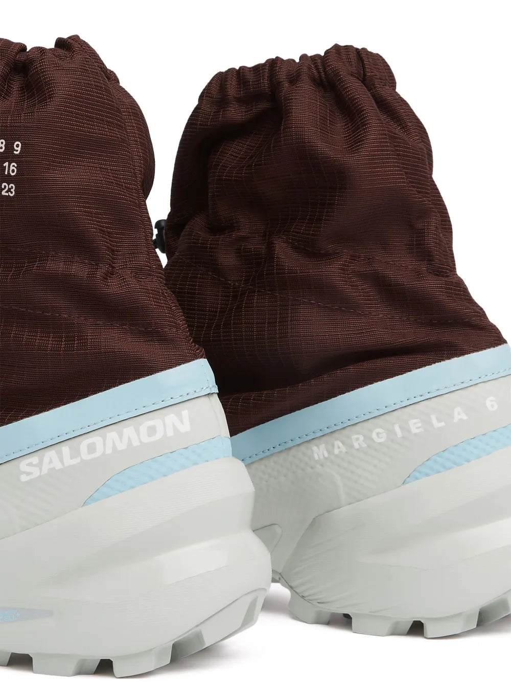 Back view of brown mid-top sneakers with light blue logo bands and chunky white sole