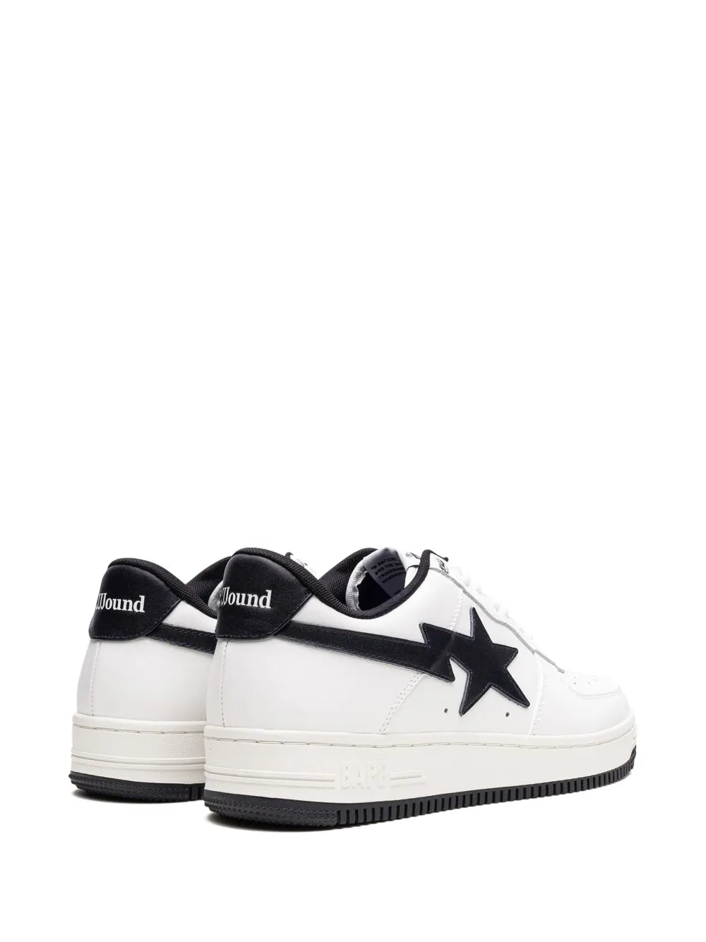Pair of white low-top sneakers with black star logos on sides and black outsoles