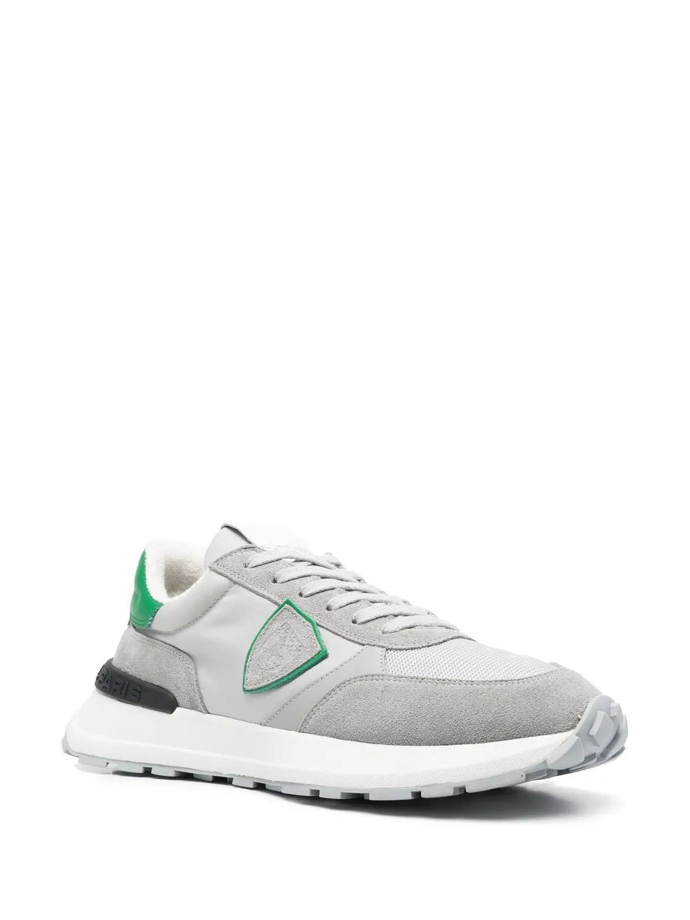 Grey low-top sneakers with green logo patch, white laces and rubber sole