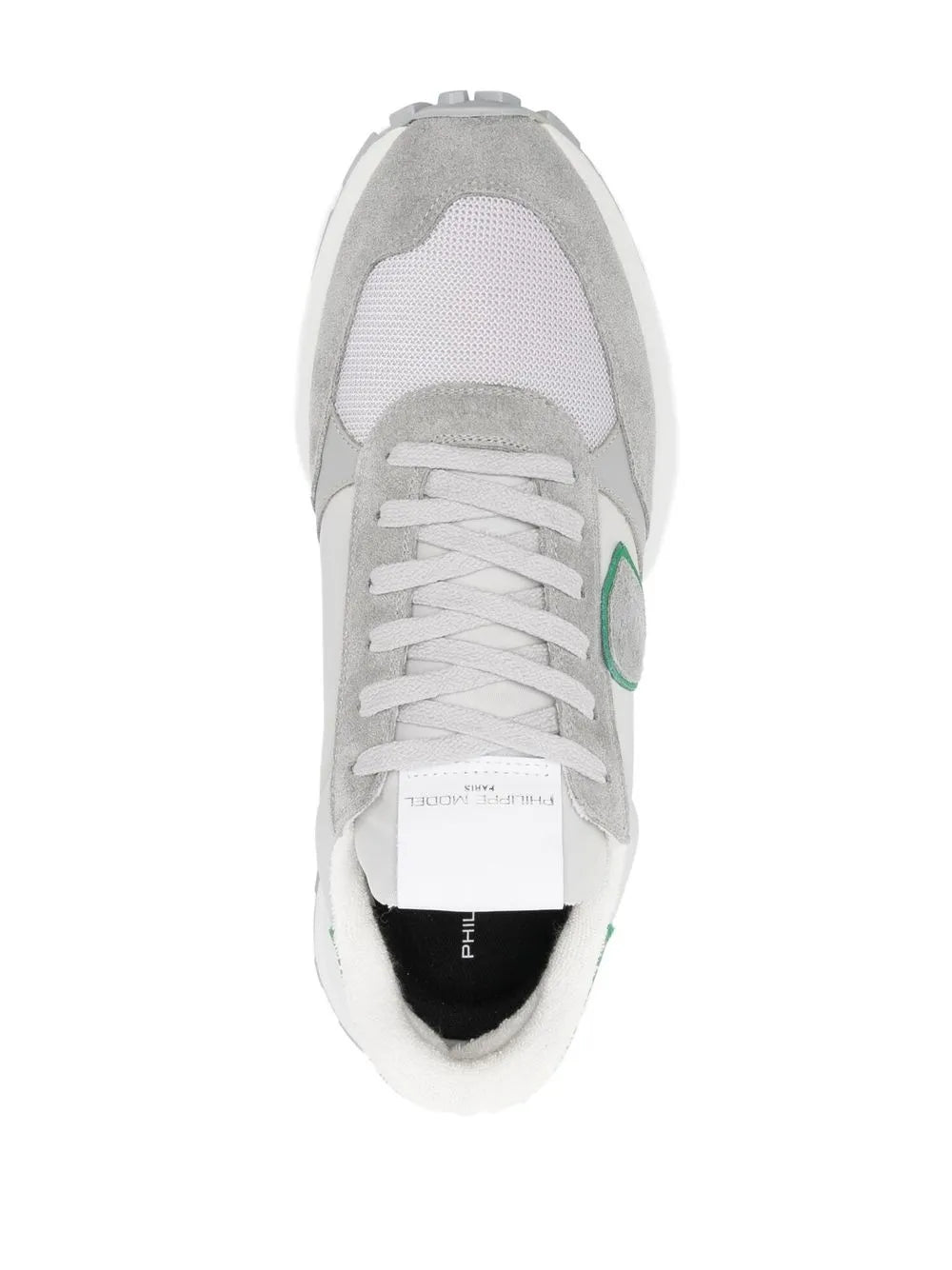 White and grey low-top sneaker view with lace-up eyelets and green accent