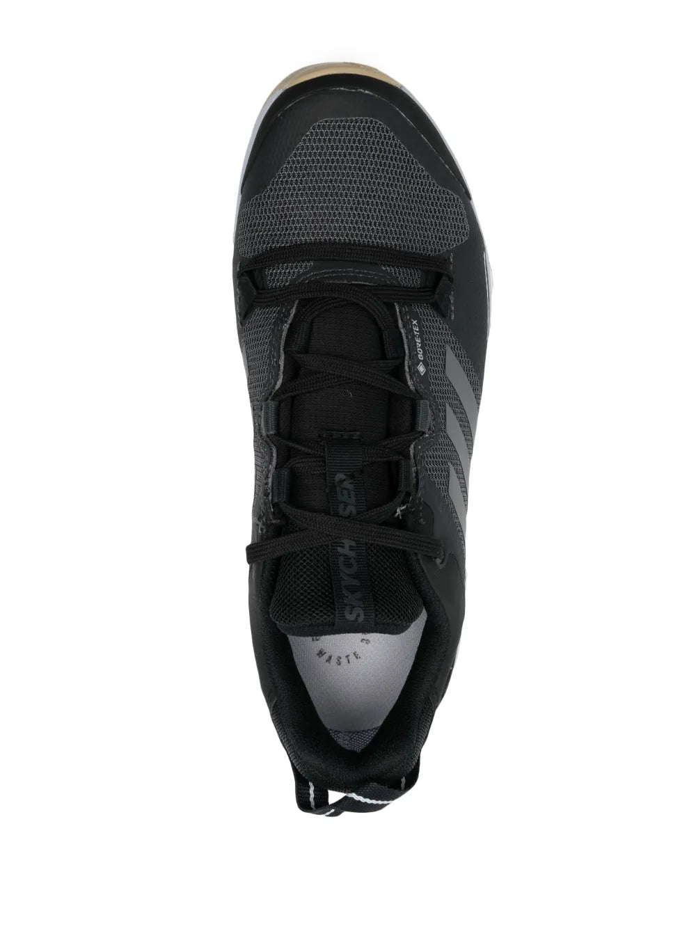 Black adidas low-top sneakers, top view of lace-up tongue and mesh upper