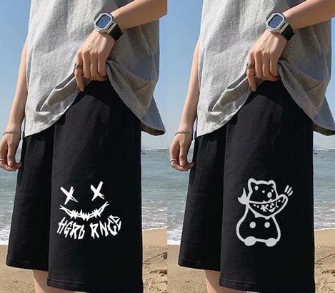 Black straight sports shorts with white skull-motif graphic; black shorts with cat graphic