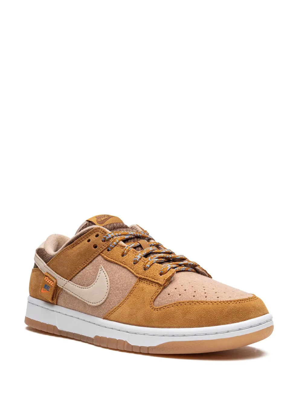 Nike Dunk Low SE sneaker with tan suede upper, cream Swoosh, lace-up front.