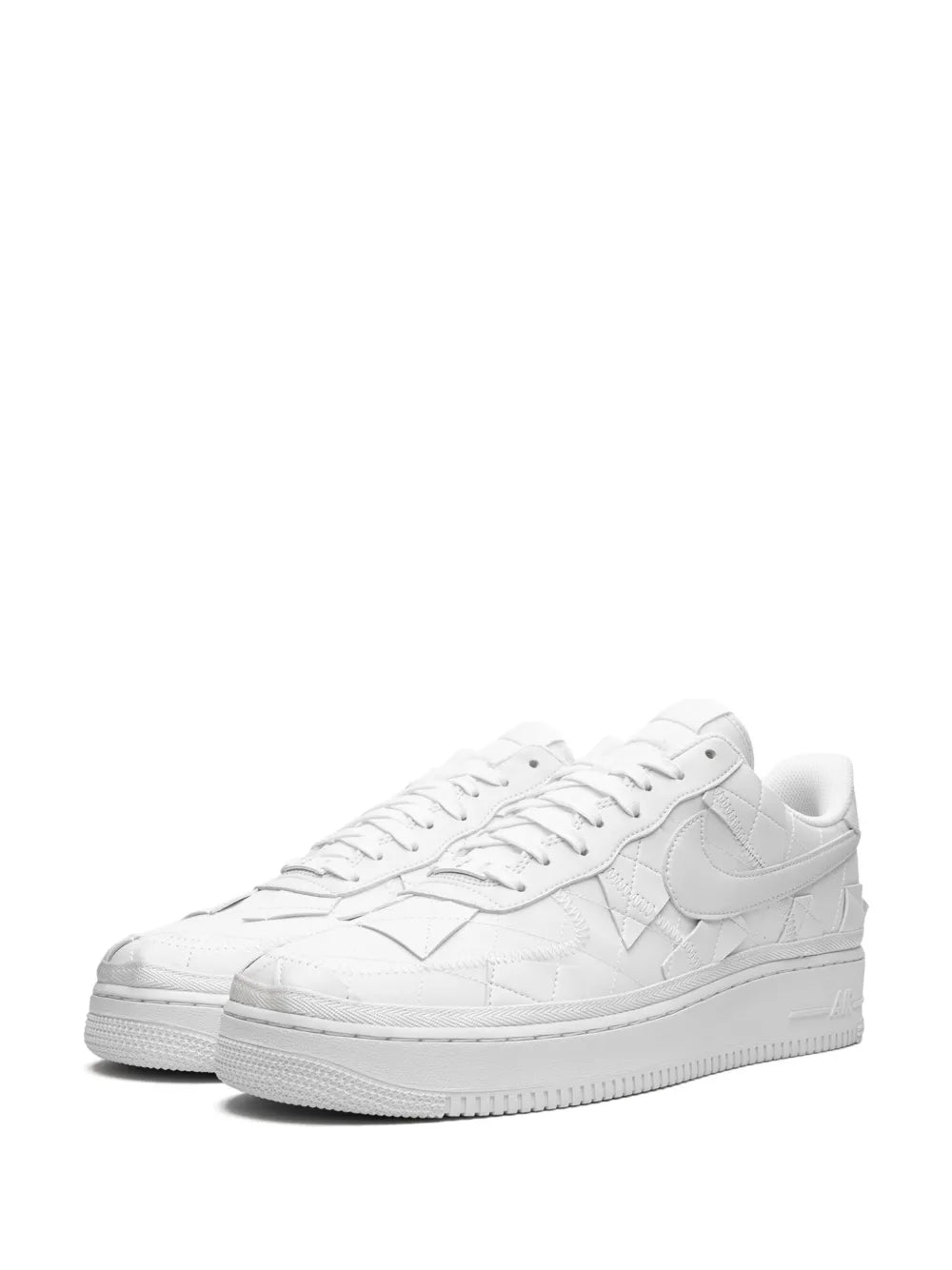 White low-top sneakers with Nike swoosh, lace-up closure, and padded collar