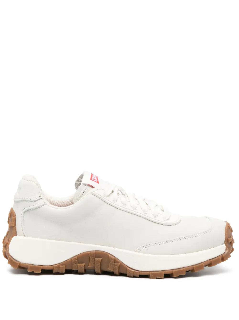 White low-top sneakers with brown rubber sole and lace-up closure