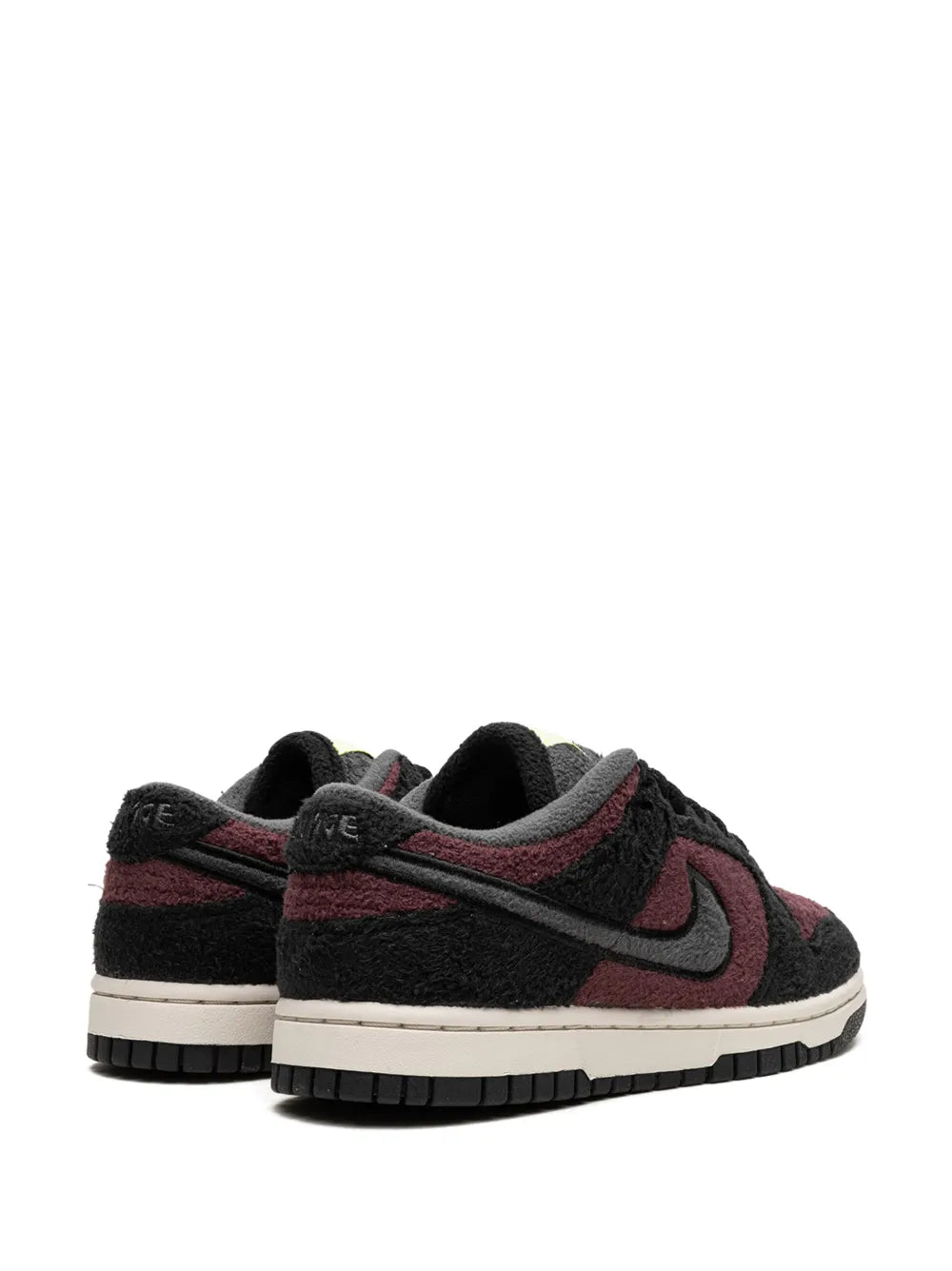 Black low-top sneakers with burgundy accents, lace-up with padded collar