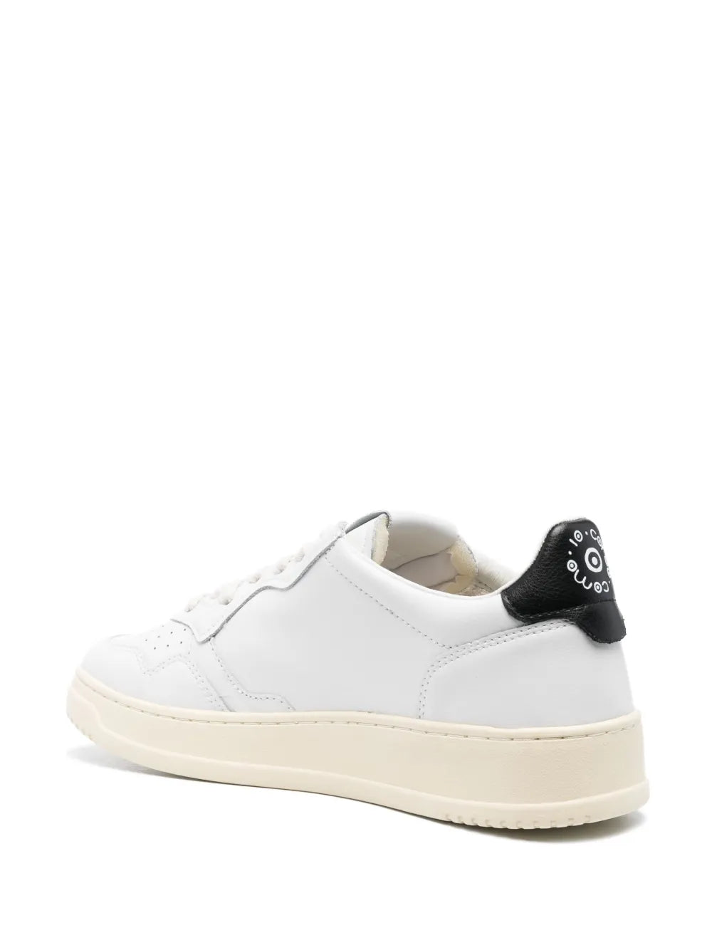 White low-top lace-up sneakers with black heel tab and cream rubber sole