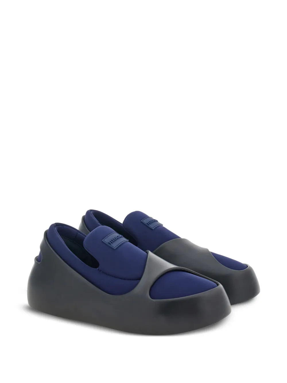Ferragamo slip-on shoes with black base and blue panels, angled back view