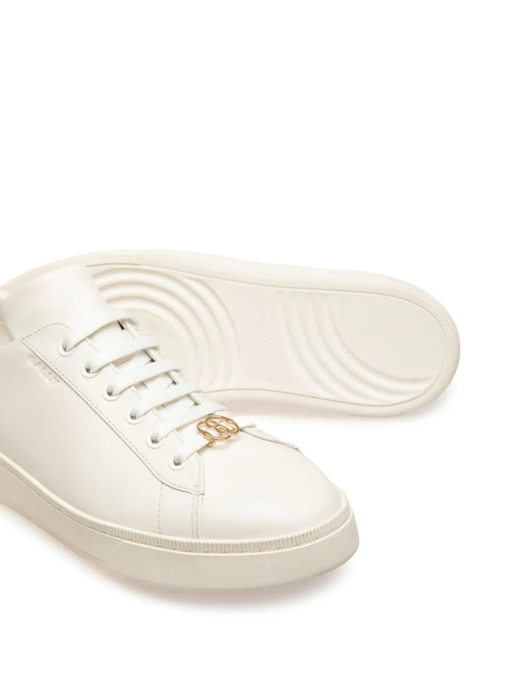 White leather sneaker outsole with textured tread and sidewall stitching, lace-up.