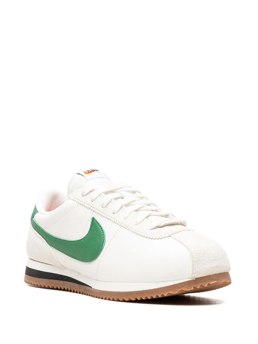 White lace-up sneaker with green Nike swoosh and textured gum outsole.