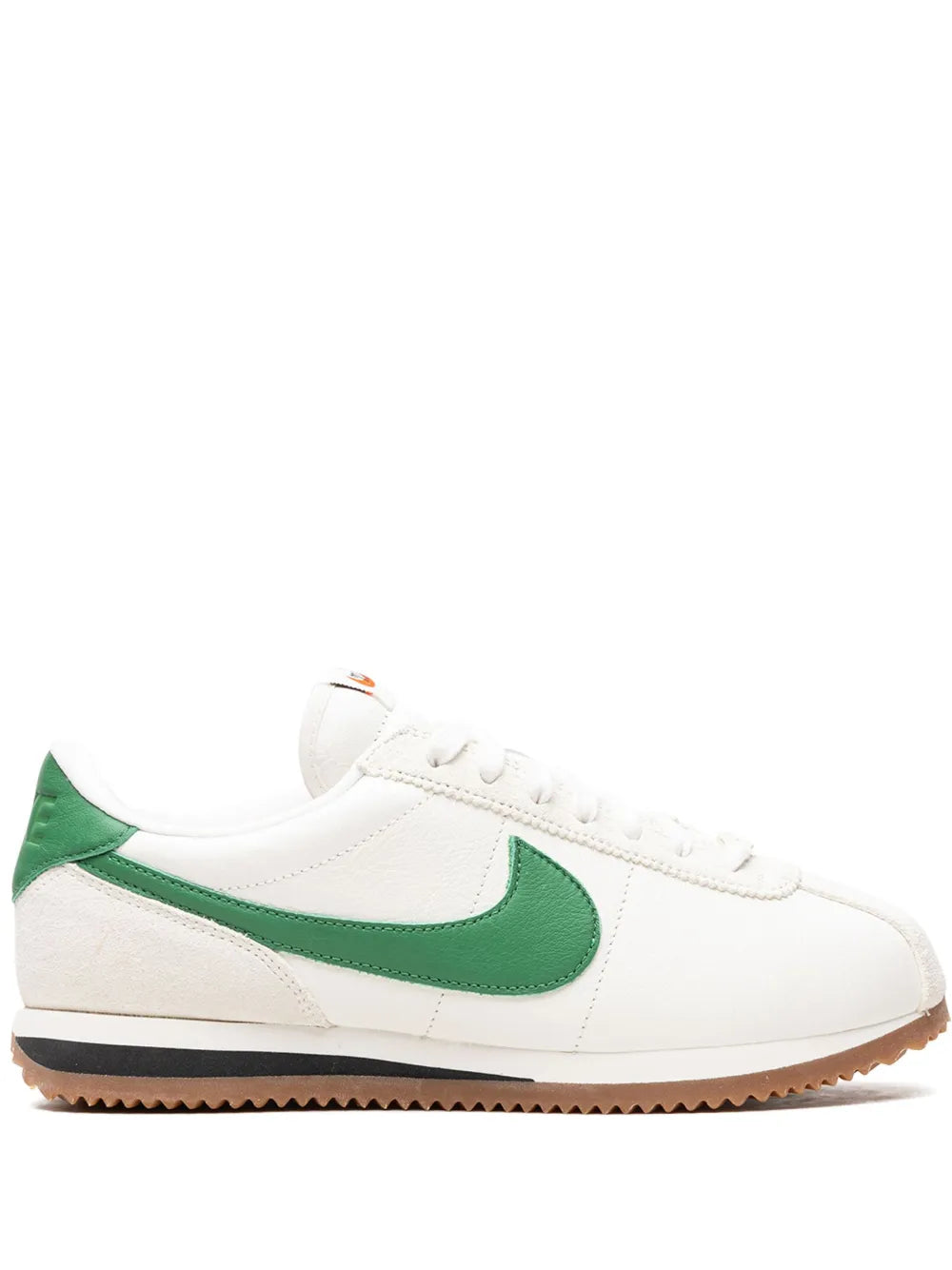 White leather sneaker with green swoosh and gum sole, lace-up design.