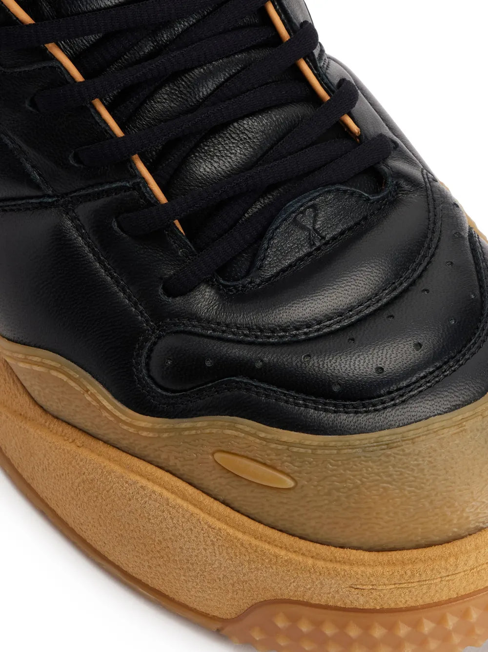 Black sneaker toe and sole close-up, paneling, brown lace details