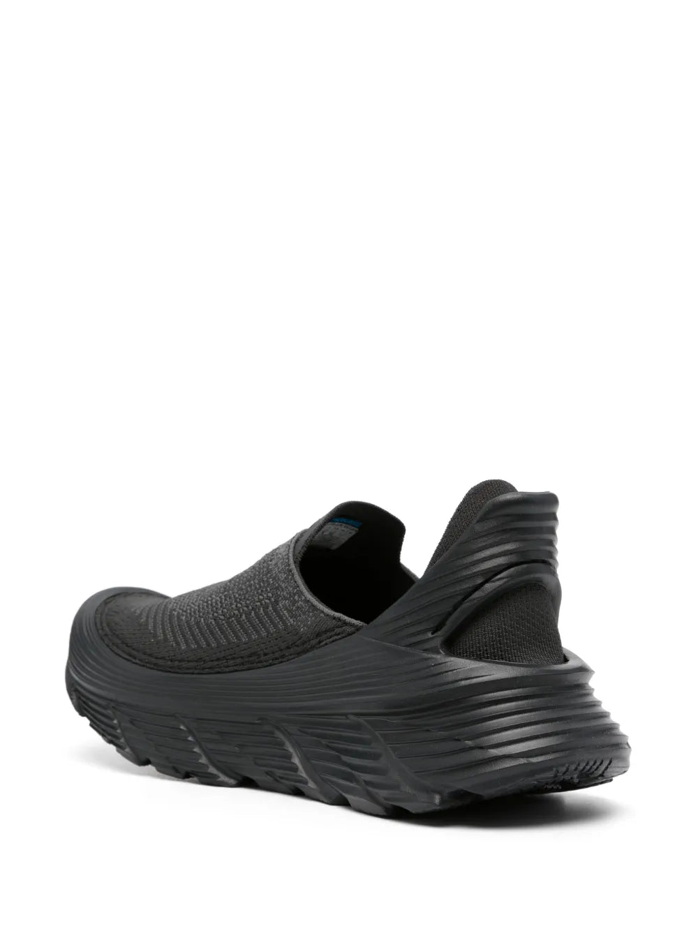 Black slip-on sneakers with open heel collar, HOKA logo, and ribbed midsole