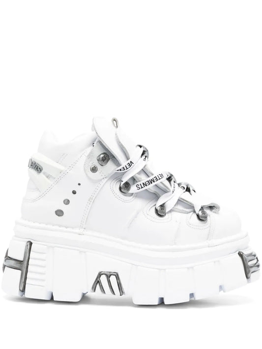 White high-top platform sneaker with buckled strap and thick tread sole