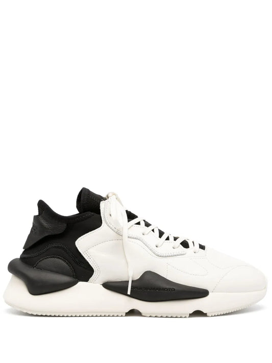 Leather sneaker with white upper, black heel and side panels, lace-up closure