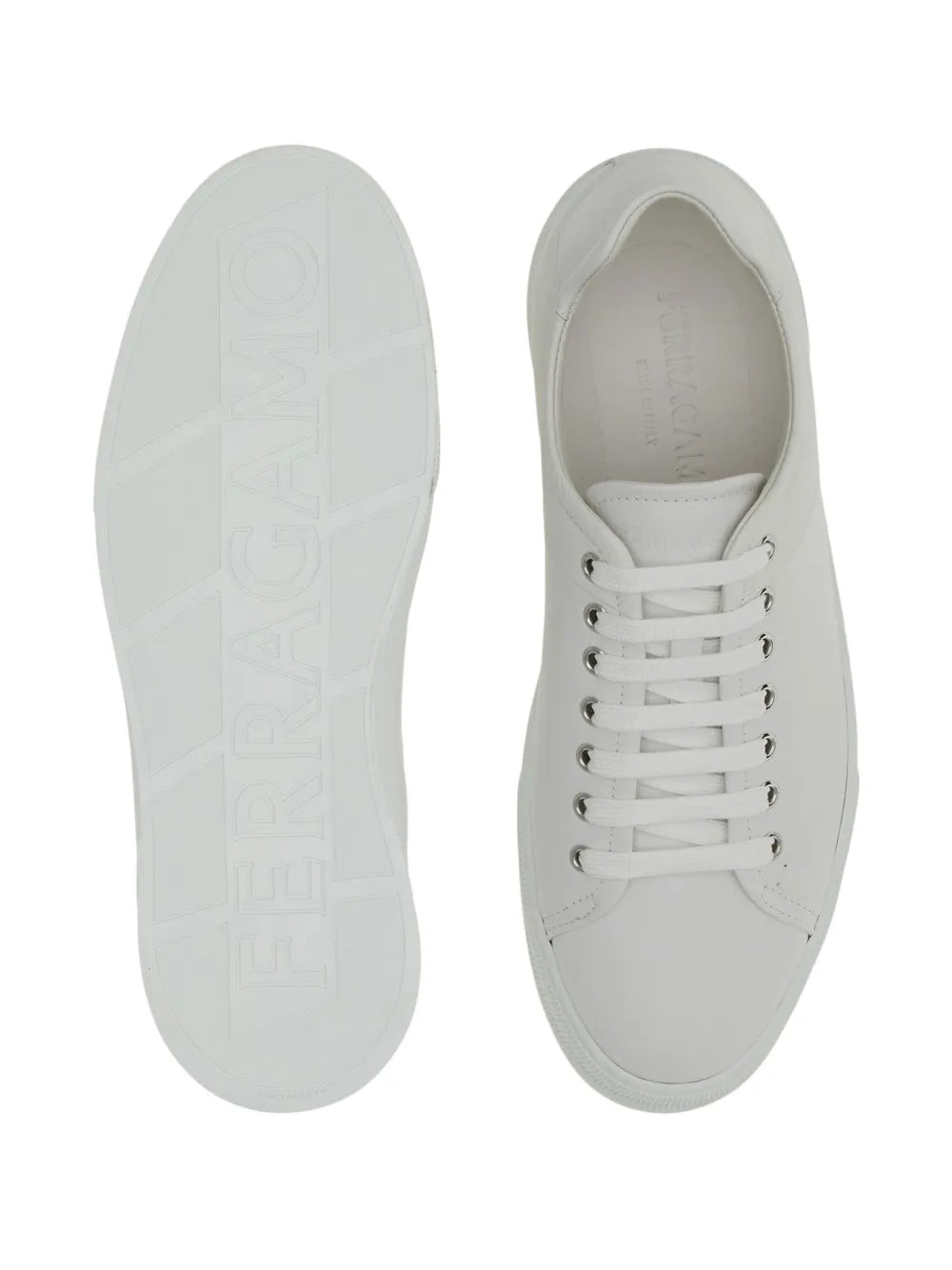 White leather sneakers outsole and side view, embossed tread pattern