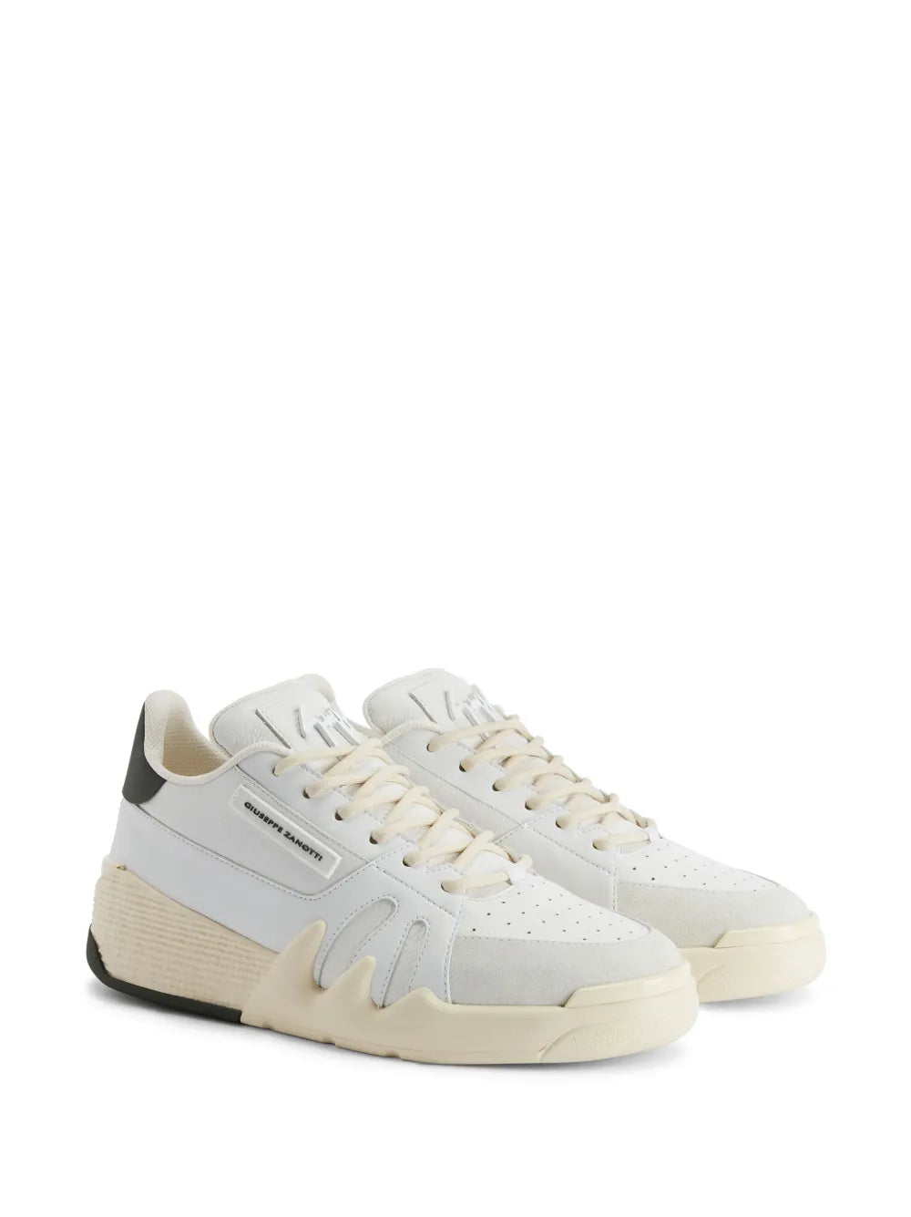 White leather lace-up sneakers with black heel tab and logo patch detail, side view.