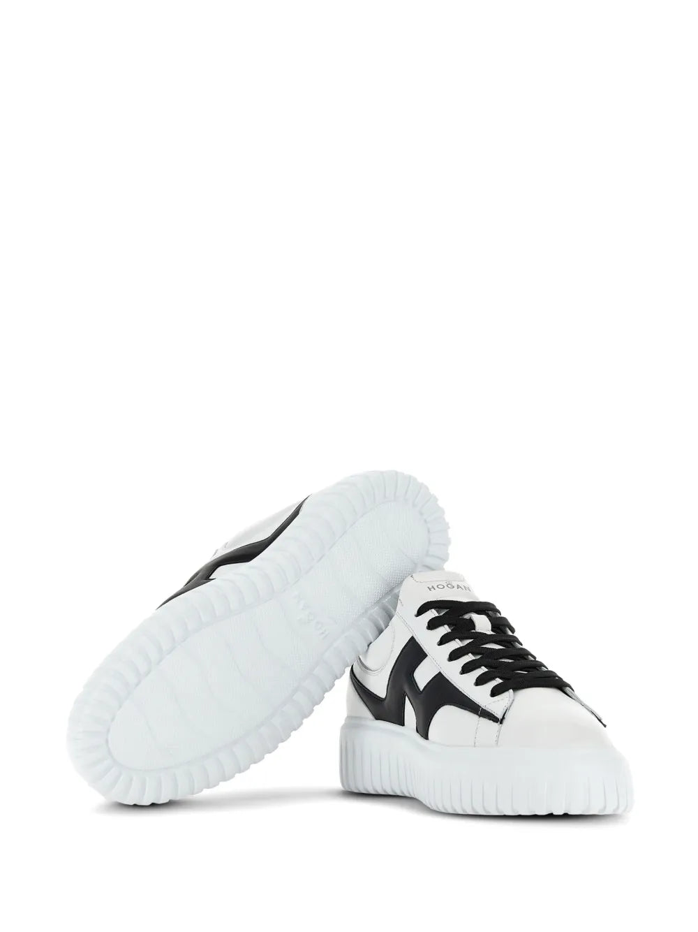 White and black lace-up sneakers with thick ridged sole, side and outsole view