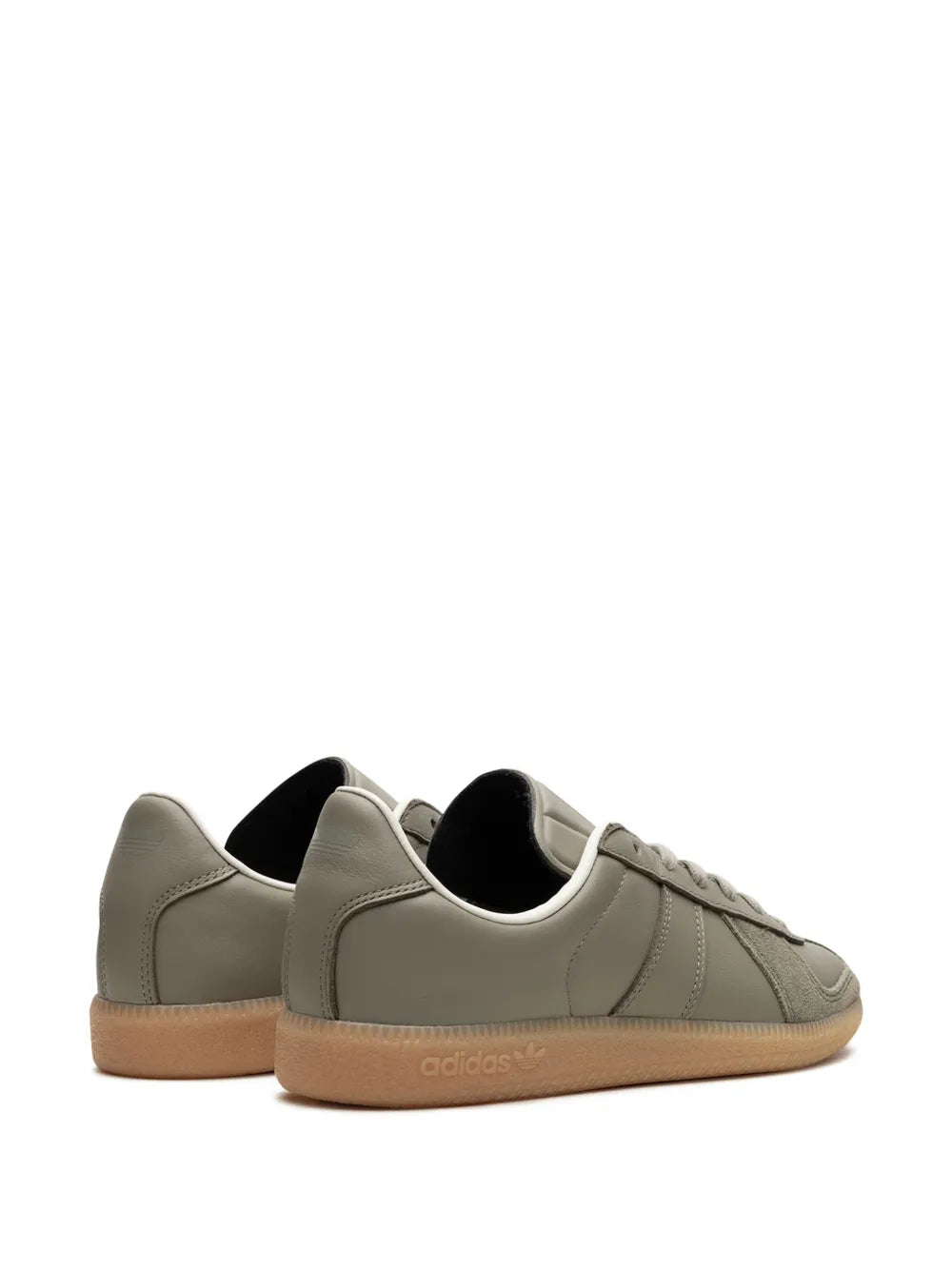 Low-top sneakers with gray upper, padded collar, and gum sole visible from heel