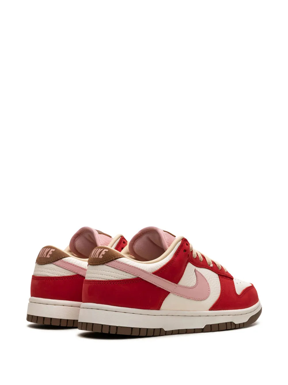 Pair of red and white low-top Nike sneakers, side view with lace-up and swoosh