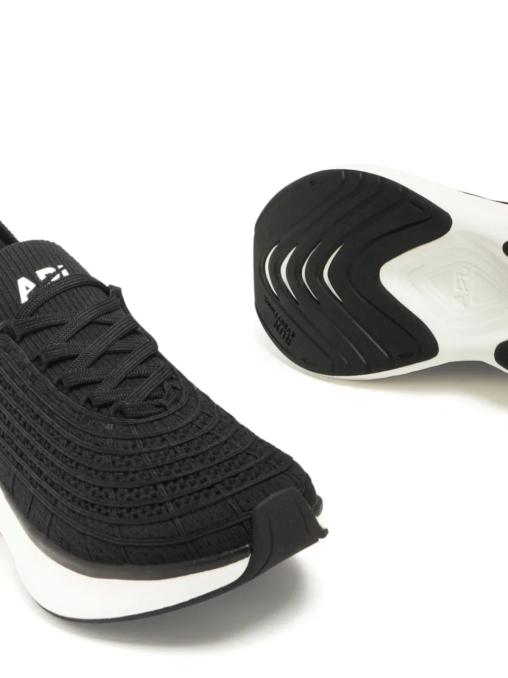 Black running shoe outsole and upper, APL logo, white midsole