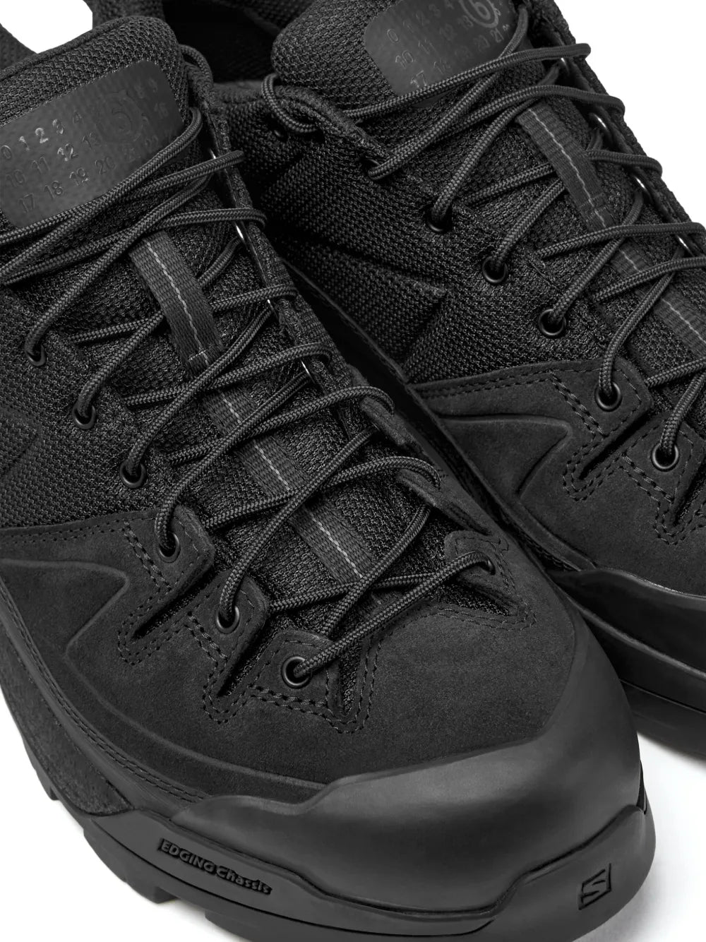 Black lace-up hiking shoes with textured suede panels and layered lace-up vamp