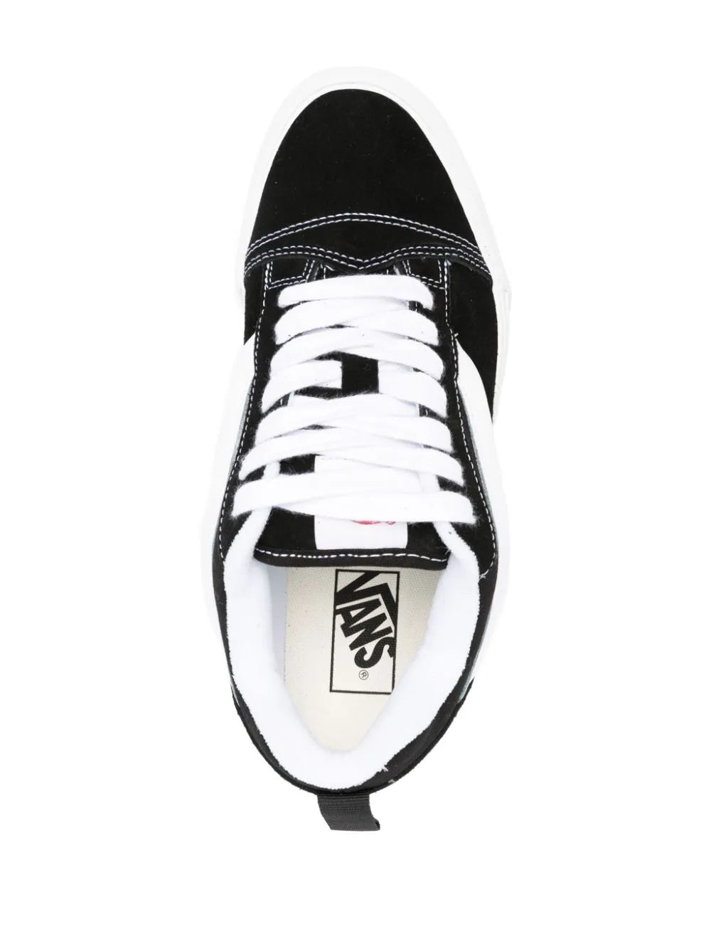 Black low-top sneakers with white laces and Vans logo tongue tag