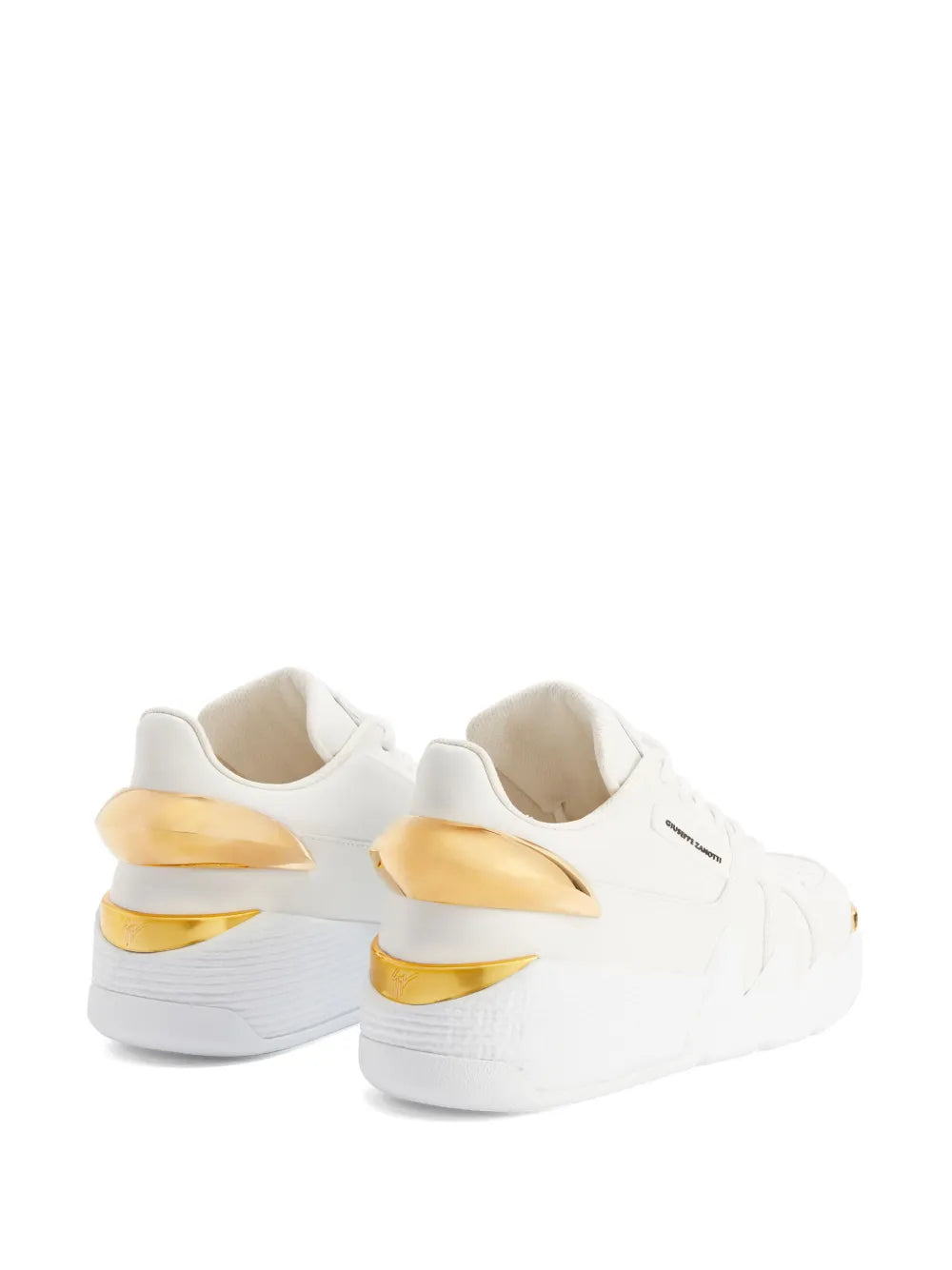 White low-top sneakers showing gold heel hardware detail and thick cushioned sole