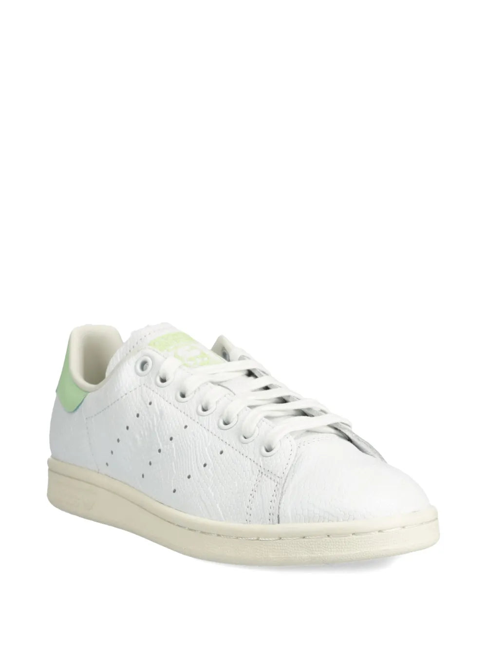 White low-top sneaker with green side stripe, lace-up eyelets, and beige sole.