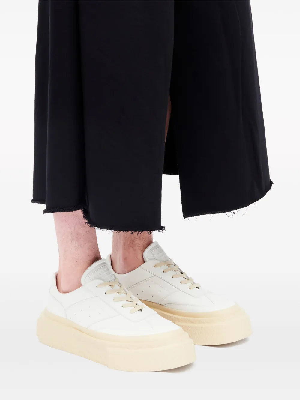 Mm6 Maison Margiela chunky leather sneakers in white with beige platform sole, worn with dark shorts