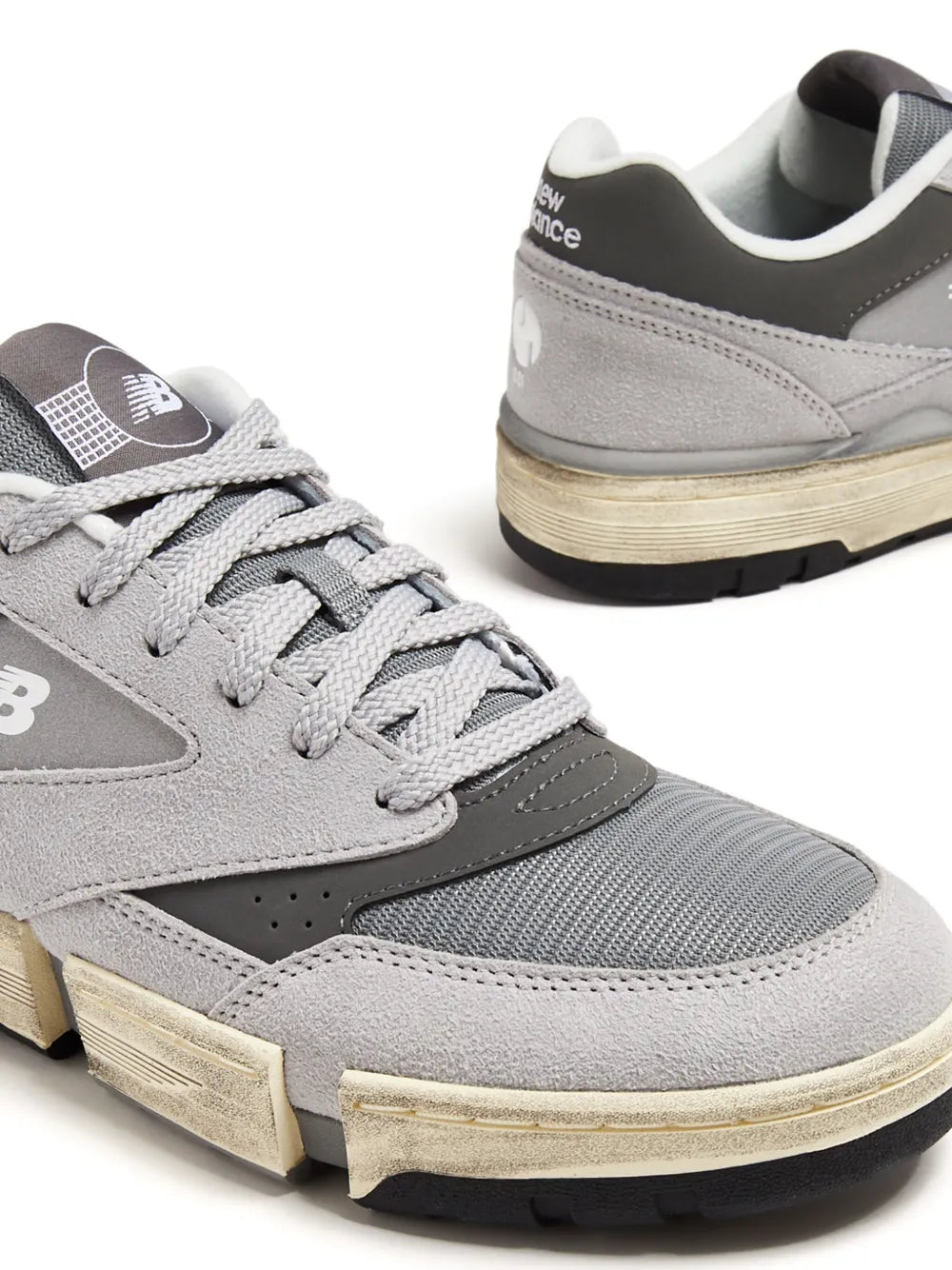 New Balance suede sneakers close-up, ash grey upper and lace-up with padded tongue.
