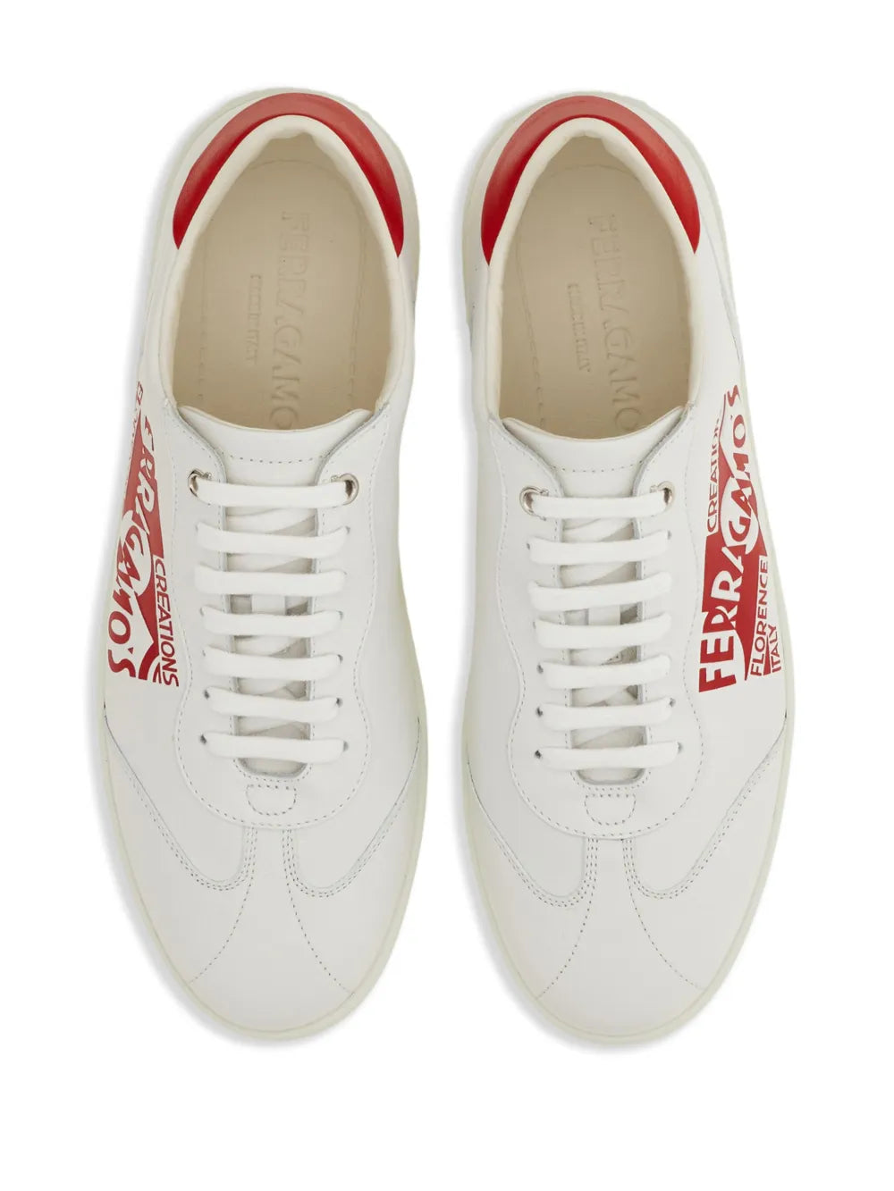 Pair of white leather sneakers with red interior trim, laces, and Ferragamo side logos